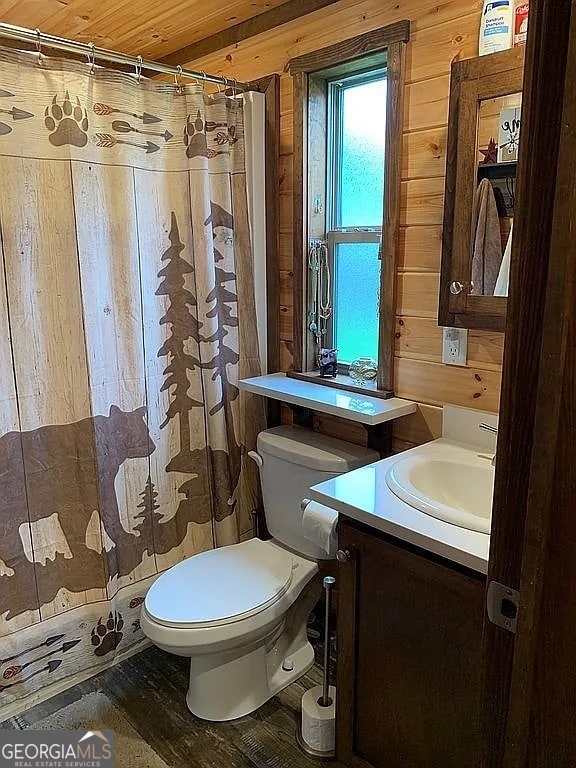 bathroom with vanity, wooden walls, hardwood / wood-style floors, and toilet