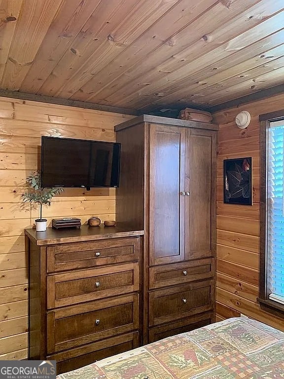 bedroom featuring wood ceiling and wood walls