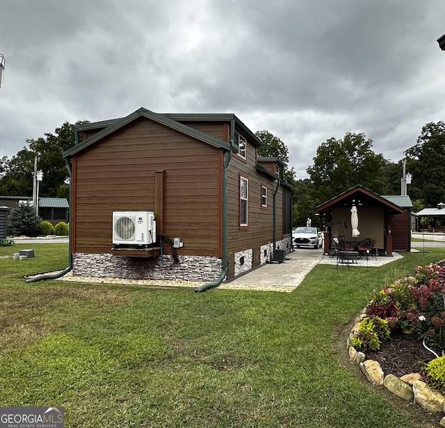 view of side of property with a lawn, ac unit, and a patio area