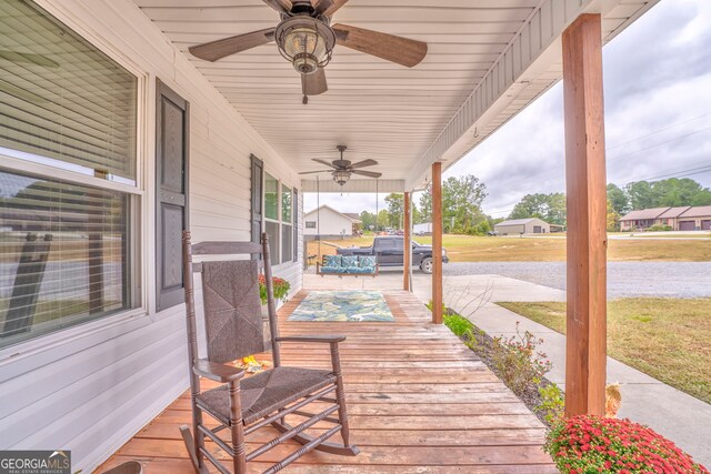 deck featuring a yard, ceiling fan, and covered porch