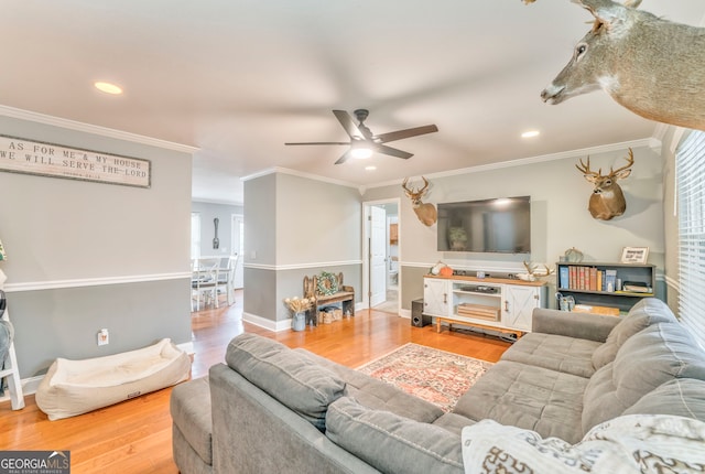 living room featuring wood-type flooring, ceiling fan, and crown molding