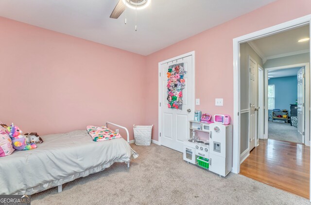 bedroom featuring ornamental molding, ceiling fan, and light hardwood / wood-style flooring