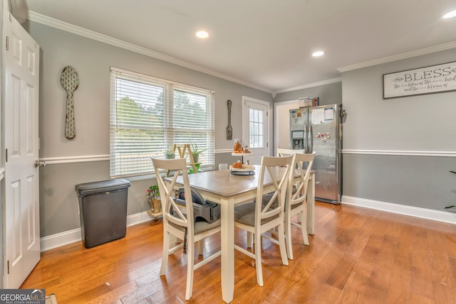 dining area with light hardwood / wood-style flooring and ornamental molding