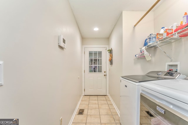 washroom with washer and clothes dryer and light tile patterned floors