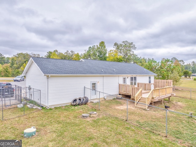 back of house featuring a wooden deck and a yard