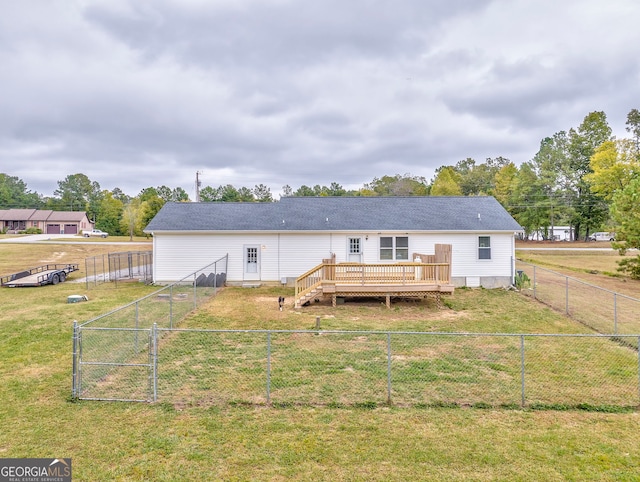 back of property with a deck and a yard