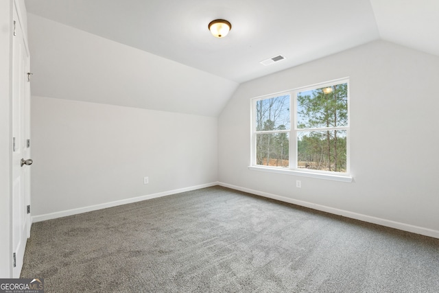 bonus room with carpet flooring and vaulted ceiling