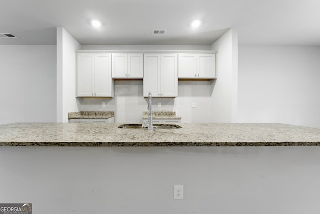 kitchen featuring white cabinetry and sink