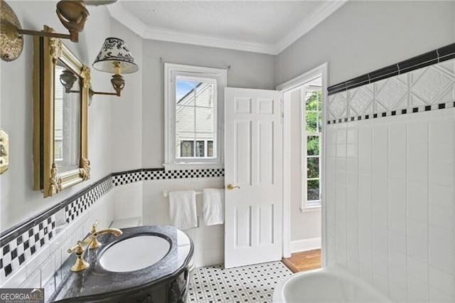 bathroom with crown molding, vanity, and tile walls