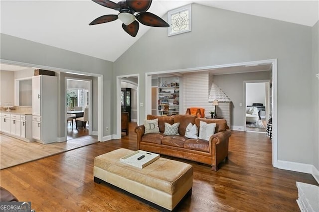 living room with high vaulted ceiling, ceiling fan, and dark wood-type flooring