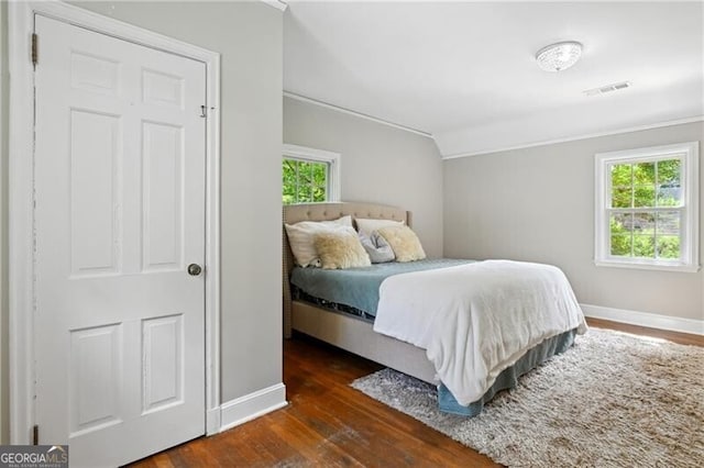 bedroom with ornamental molding and dark hardwood / wood-style flooring