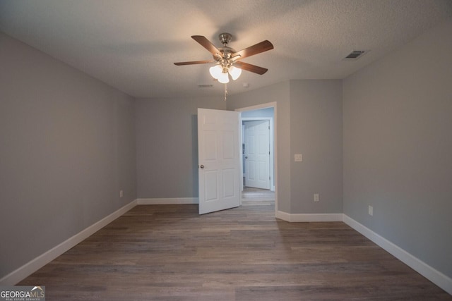 empty room featuring ceiling fan, a textured ceiling, and dark hardwood / wood-style flooring