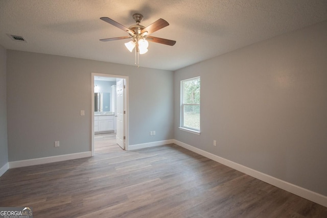 spare room with ceiling fan, hardwood / wood-style flooring, and a textured ceiling