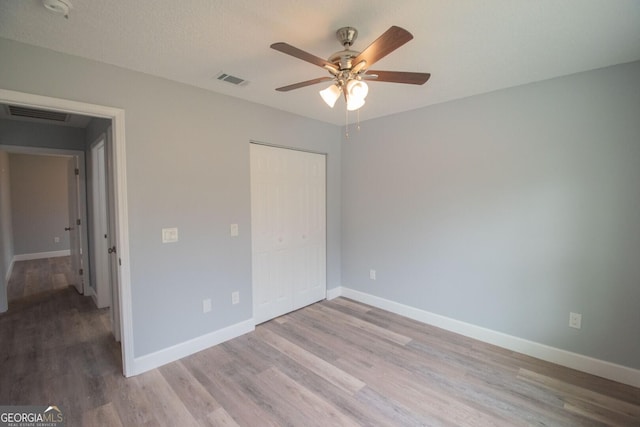 unfurnished bedroom with a closet, ceiling fan, and light wood-type flooring