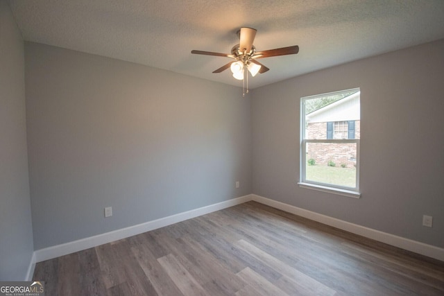 spare room with ceiling fan, wood-type flooring, and a textured ceiling