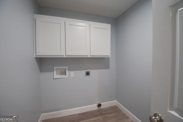washroom with hookup for a washing machine, wood-type flooring, electric dryer hookup, and cabinets
