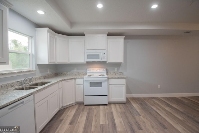 kitchen featuring sink, light wood-type flooring, white appliances, light stone countertops, and white cabinets