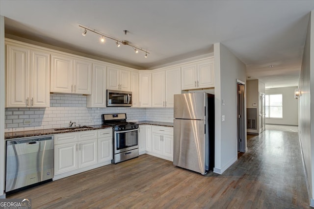 kitchen featuring stainless steel appliances, white cabinetry, and hardwood / wood-style flooring