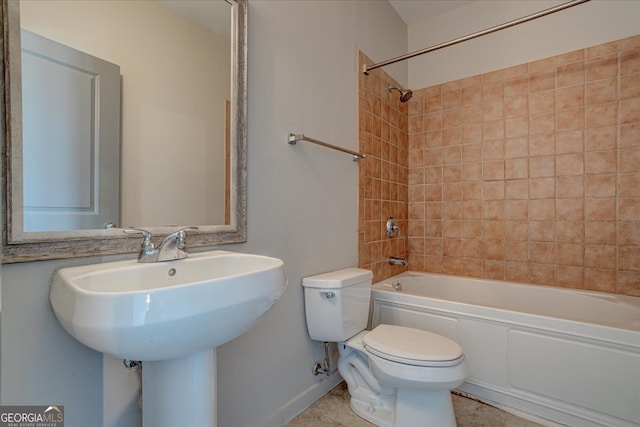 bathroom featuring tiled shower / bath combo and toilet