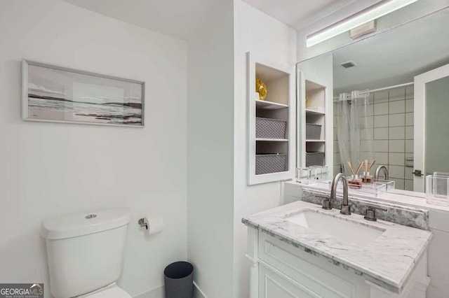 bathroom with vanity, toilet, and a tile shower