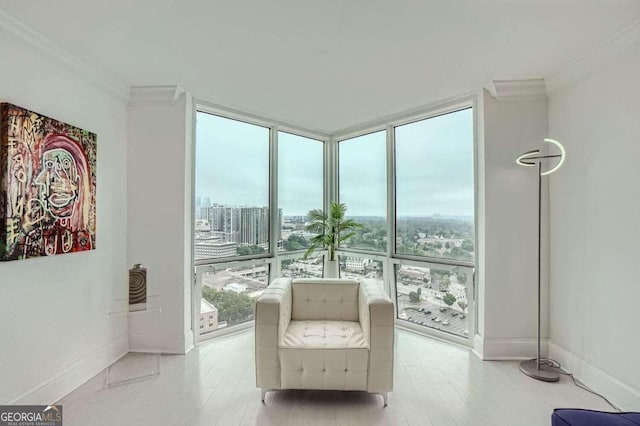 unfurnished room with a wall of windows, ornamental molding, and light wood-type flooring