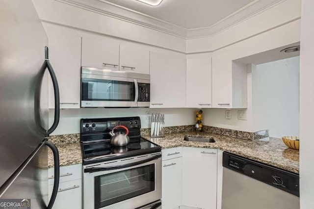 kitchen featuring sink, white cabinetry, crown molding, dark stone counters, and stainless steel appliances