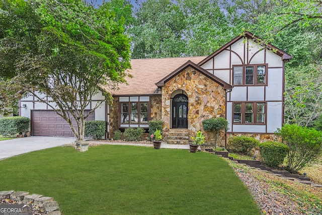 english style home featuring a garage and a front lawn