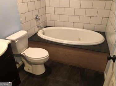 bathroom featuring vanity, a bathtub, and toilet