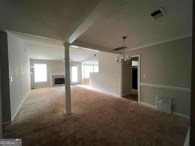 unfurnished living room with carpet, a textured ceiling, vaulted ceiling with beams, decorative columns, and a chandelier