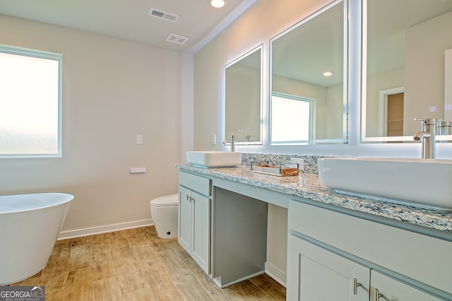 bathroom with vanity, hardwood / wood-style floors, toilet, and a wealth of natural light