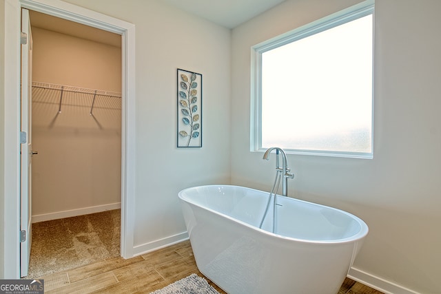 bathroom with a bathing tub and hardwood / wood-style floors