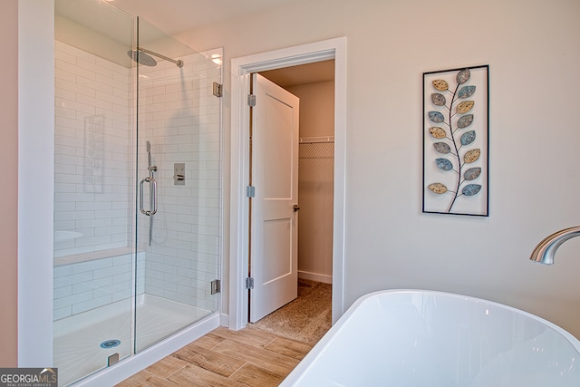 bathroom with hardwood / wood-style floors and plus walk in shower