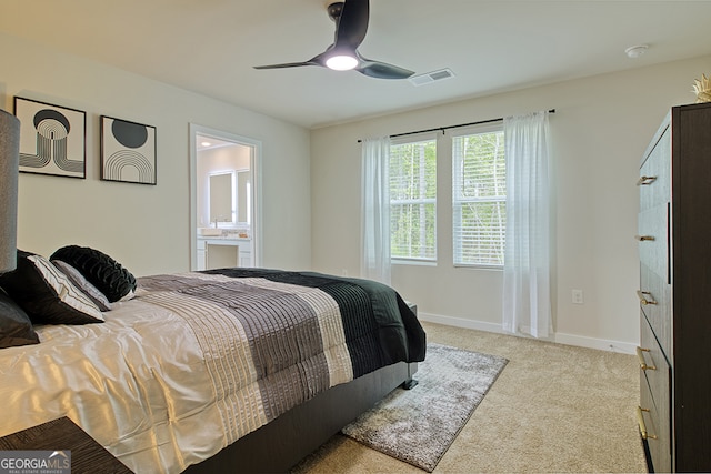 bedroom featuring ensuite bath, ceiling fan, and light colored carpet