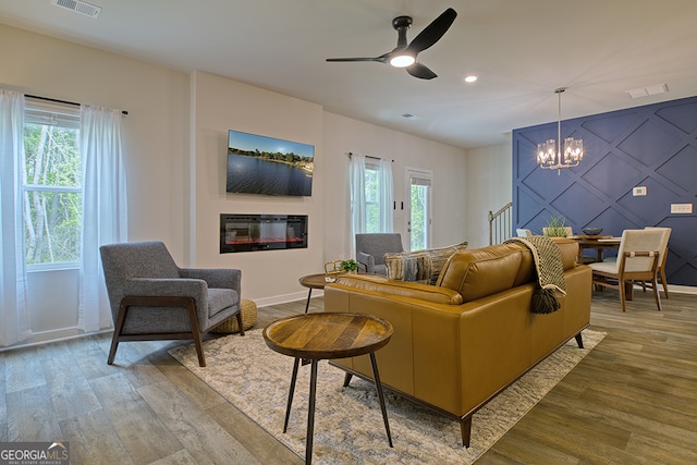 living room featuring ceiling fan with notable chandelier and light hardwood / wood-style floors