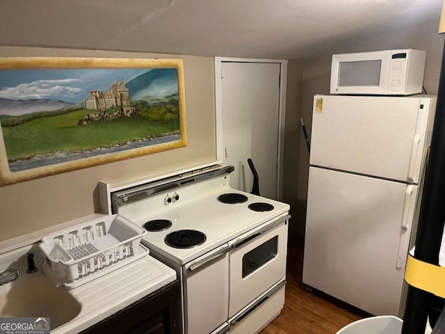 kitchen featuring white appliances and dark hardwood / wood-style flooring