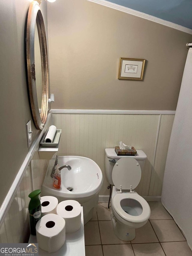 bathroom with ornamental molding, toilet, and tile patterned floors