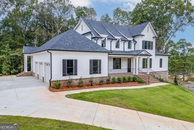 view of front of property featuring a front lawn, a porch, and a garage