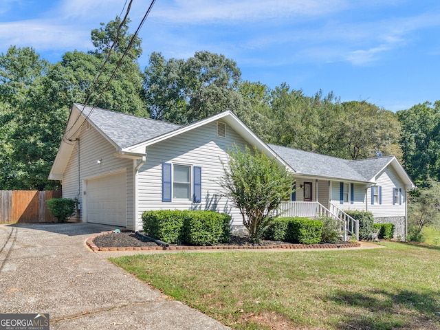 ranch-style home with covered porch, a front yard, and a garage