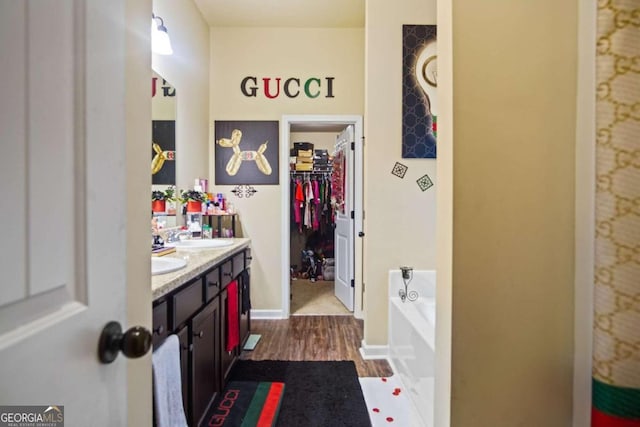 bathroom featuring a tub to relax in, hardwood / wood-style flooring, and vanity