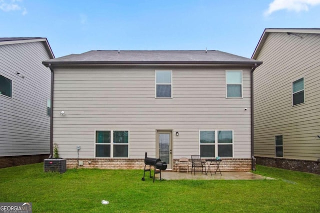 back of property with a lawn and a patio