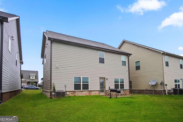 rear view of house with a lawn and central air condition unit