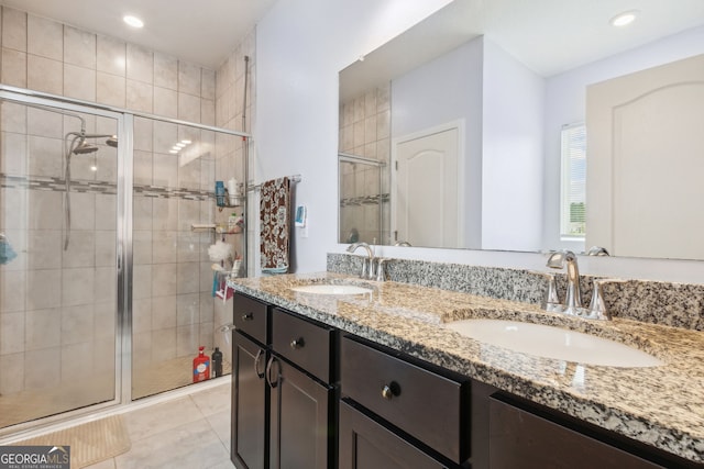 bathroom featuring tile patterned floors, a shower with shower door, and vanity