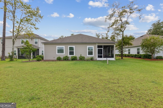 back of property with a sunroom and a yard