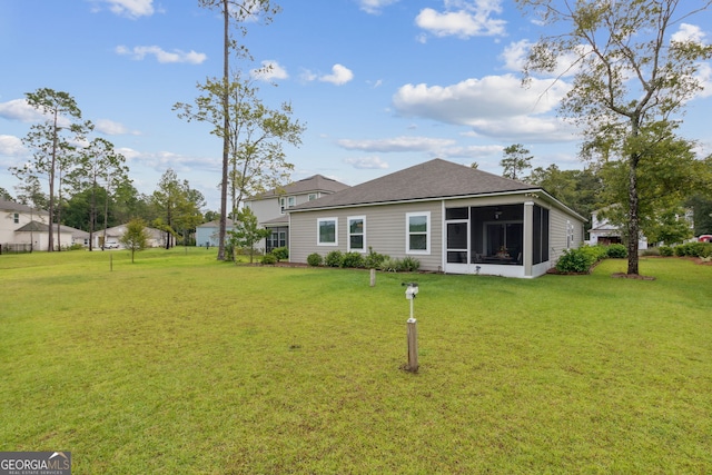 back of house with a sunroom and a yard