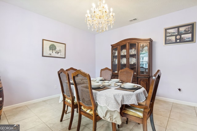 dining room with a chandelier and light tile patterned floors