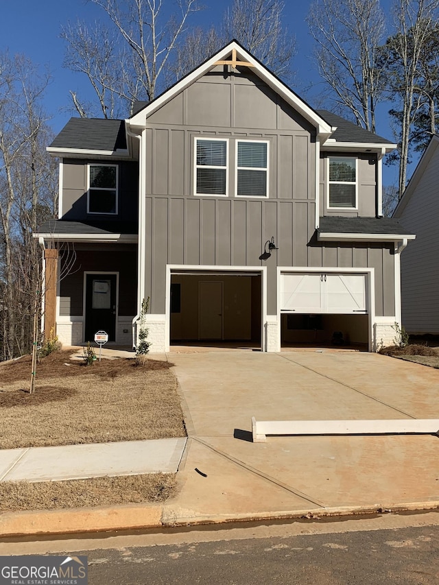 view of front of property featuring driveway, board and batten siding, and an attached garage