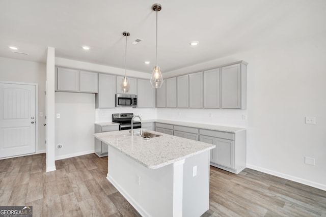 kitchen with appliances with stainless steel finishes, gray cabinets, and a sink