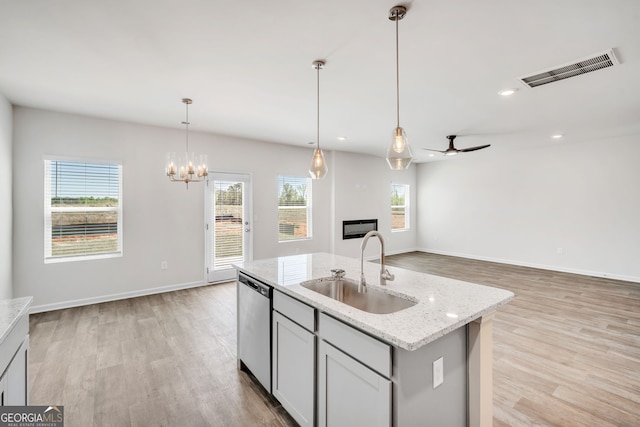 kitchen featuring light wood-style flooring, a sink, visible vents, open floor plan, and dishwasher