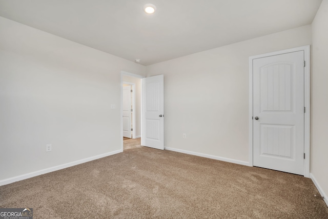 carpeted spare room with baseboards