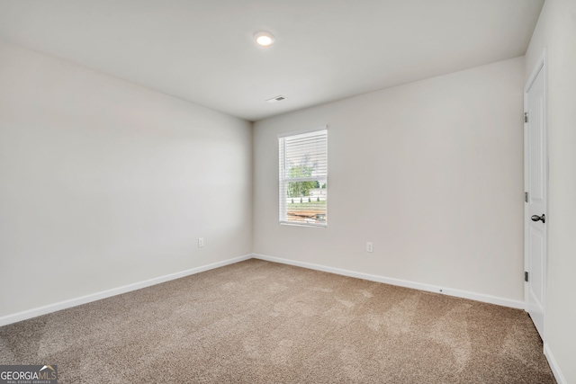 unfurnished room featuring carpet flooring, visible vents, and baseboards